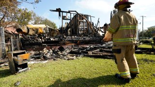 A fireman observes the remains of a burned Epiphany Lutheran Church near midtown Jackson, Miss., Tuesday, Nov. 8, 2022.