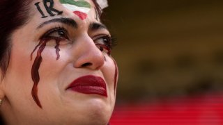 An Iranian woman, name not given, breaks into tears after a member of security seized her flag reading "Woman Life Freedom" before the start of the World Cup group B soccer match