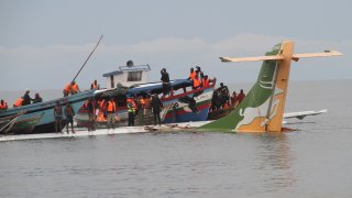 Rescuers search for survivors after a Precision Air flight that was carrying 43 people plunged into Lake Victoria