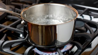 FILE - Water bubbles and boils on a gas stove
