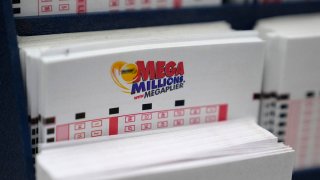 A display holds Mega Million lottery ticket wagering cards at Ted's State Line Mobil station, Jan. 5, 2023, in Methuen, Mass.