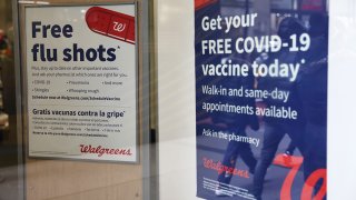 FILE - Flu and coronavirus (COVID-19) vaccine signage is seen at a Duane Reade on Jan. 5, 2023, in New York City.