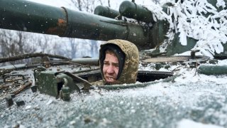 A Ukrainian soldier looks out of a self-propelled artillery vehicle