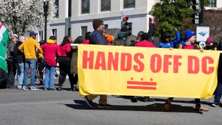 Demonstrators hold a banner during a protest in front of the Dirksen Senate Office Building, Wednesday, March 8, 2023, on Capitol Hill in Washington. Protestors rallied against a Republican-sponsored resolution blocking new District of Columbia laws that would overhaul how the nation’s capital prosecutes and punishes crime.