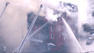 Firefighters battle a blaze at a building in New Bedford, Massachusetts, on Tuesday, March 28, 2023.