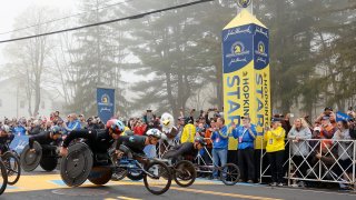 Men's wheelchair athletes Daniel Romanchuk (W1) and Marcel Hug (W2), of Switzerland, break from the starting line with others during the 127th Boston Marathon, Monday, April 17, 2023, in Hopkinton, Mass.