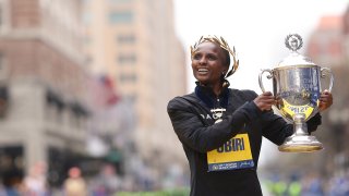 Hellen Obiri of Kenya poses with the trophy on the finish line after winning the professional Women's Division during the 127th Boston Marathon on April 17, 2023 in Boston, Massachusetts.