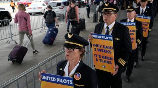 Members of the Airline Pilots Association International walk an informational picket on behalf of United Airline pilots at O'Hare International Airport, May 12, 2023, in Chicago.