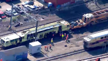 Train workers at the scene of an incident in Boston's Hyde Park neighborhood on Friday, May 12, 2023.