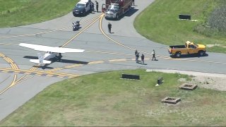 First responders near a small plane at Norwood Memorial Airport on Friday, May 26, 2023.