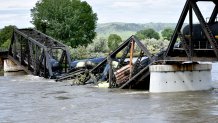 Several train cars are immersed in the Yellowstone River after a bridge collapse near Columbus, Mont., on Saturday, June 24, 2023.  