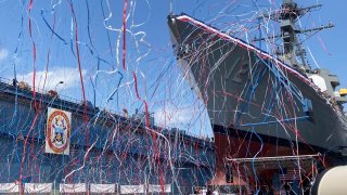 Streamers are shot in the air as a future U.S. Navy destroyer bearing the name of Medal of Honor recipient Barney Barnum is christened at Bath Iron Works on Saturday, July 29, 2023, in Bath, Maine. (AP Photo/David Sharp)