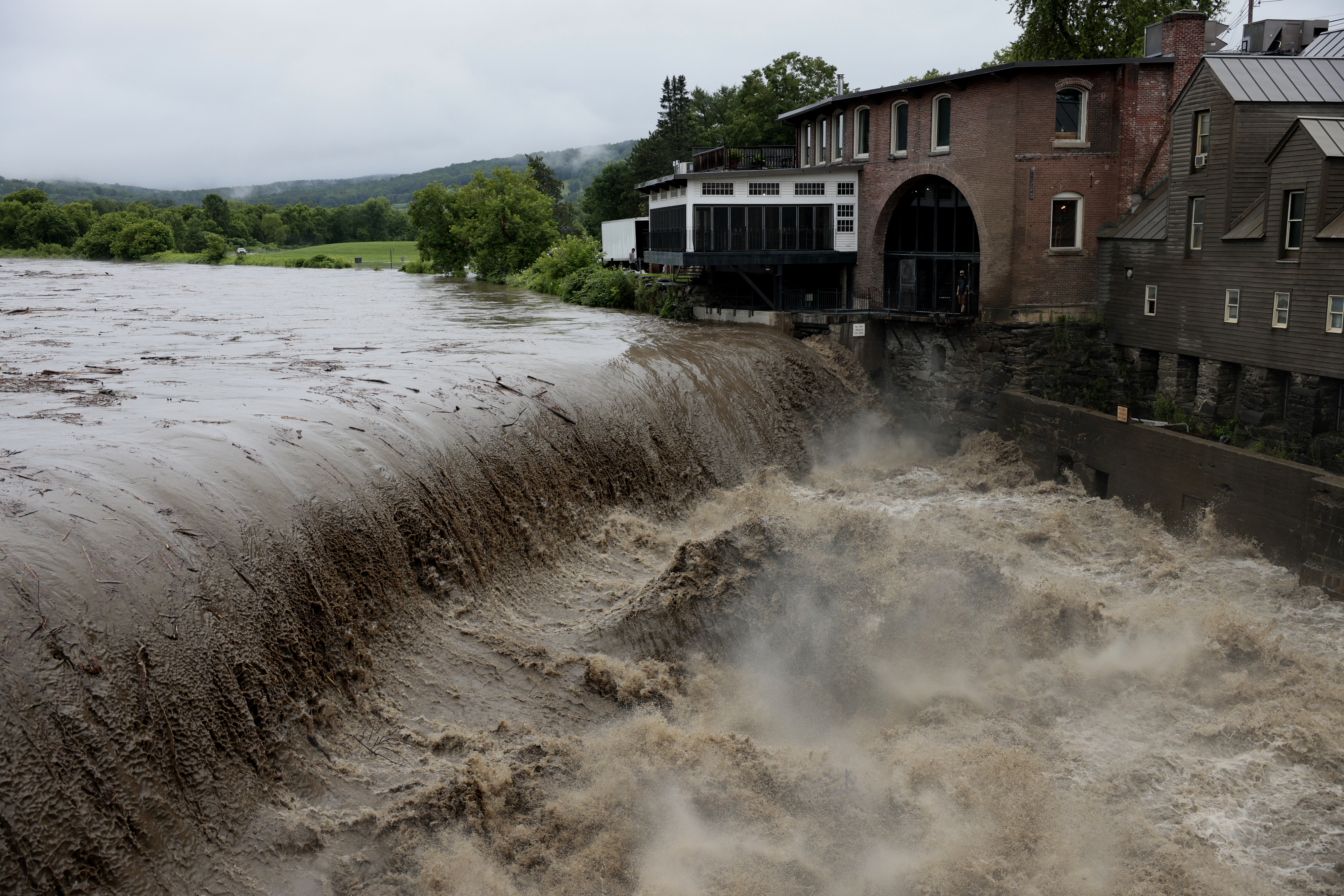 Heavy rain sends mud and debris down the Ottauquechee River in Quechee, Vermont, on Monday, July 10, 2023.