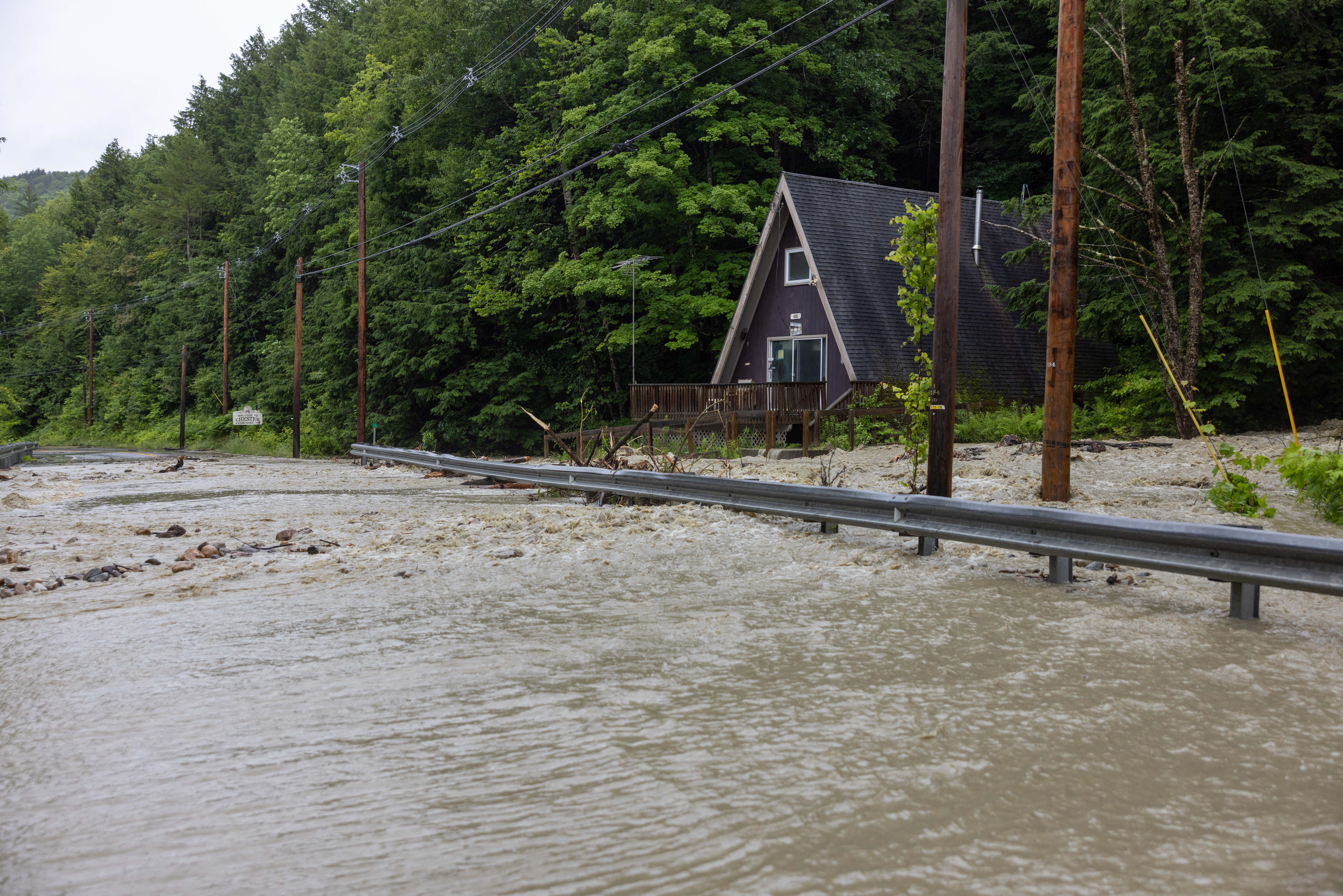 Water floods around a house on Vermont’s Route 11 in Windham on Monday, July 10, 2023. Torrential rain and flooding has affected millions of people from Vermont south to North Carolina.