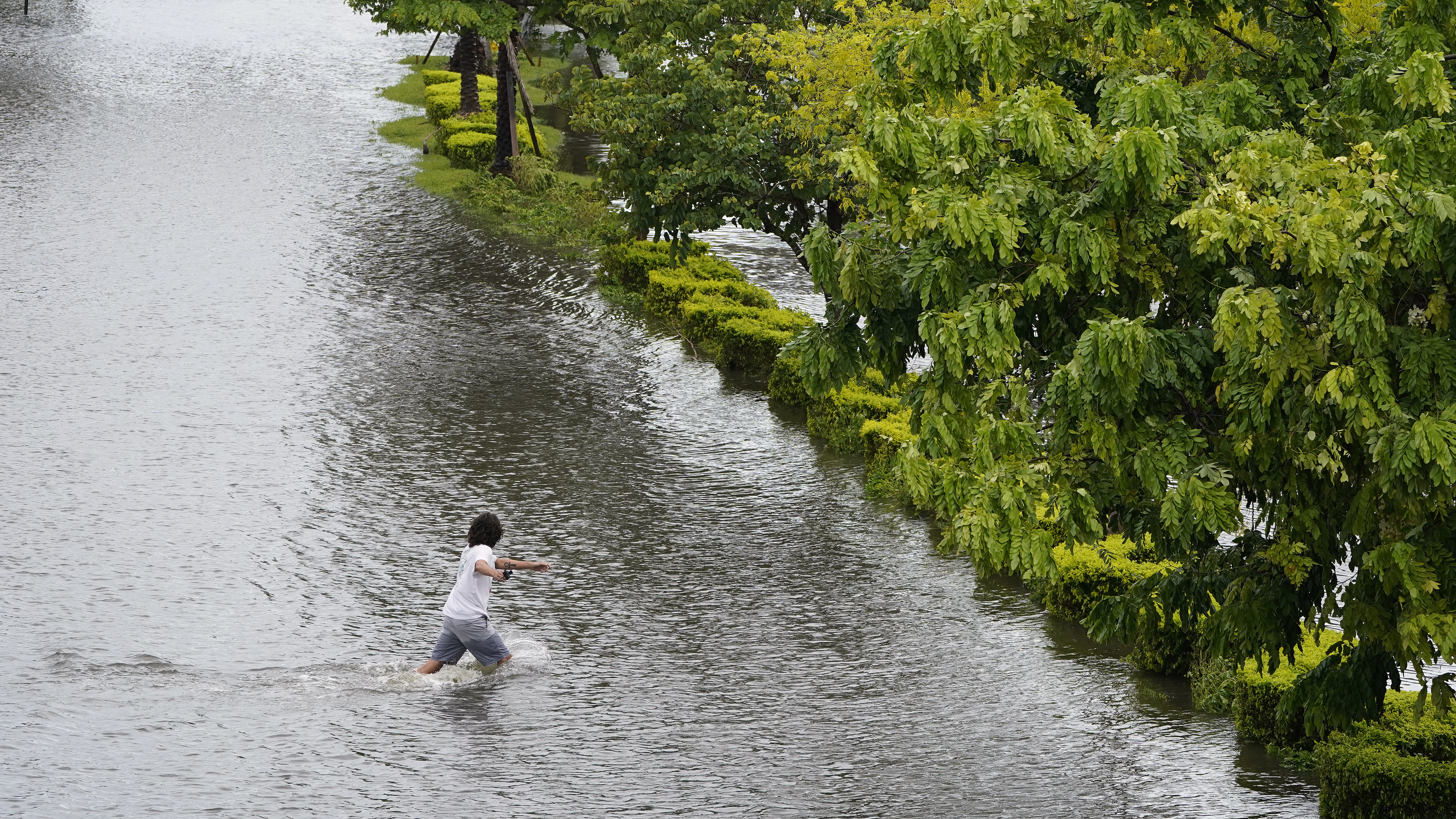 A man runs across a flooded Bayshore Blvd., from the storm surge brought on by Hurricane Idalia, Aug. 30, 2023, in Tampa, Florida.