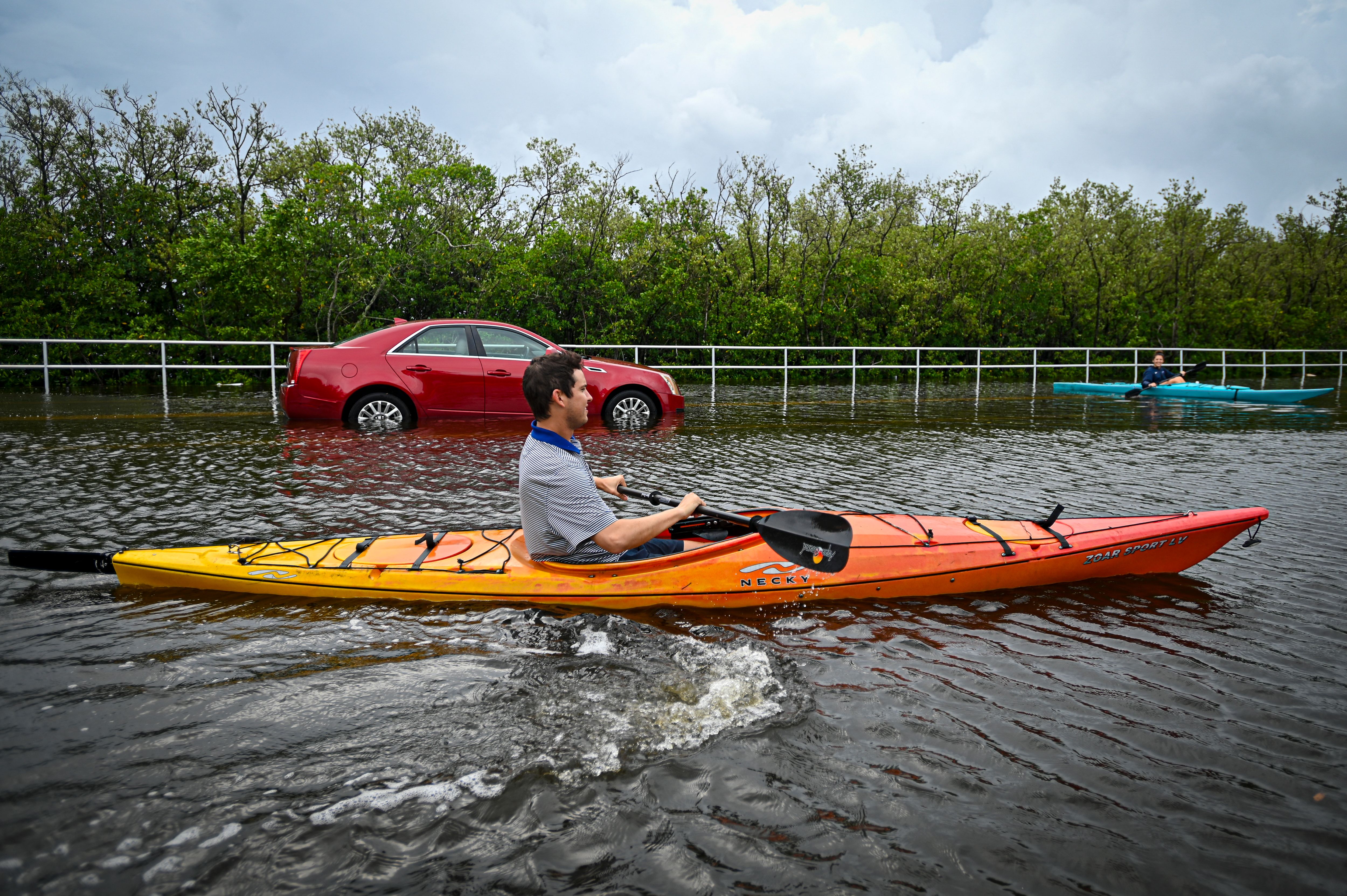 Residents use kayaks to travel on a flooded road in Tampa, Florida, Aug. 30, 2023, after Hurricane Idalia made landfall.