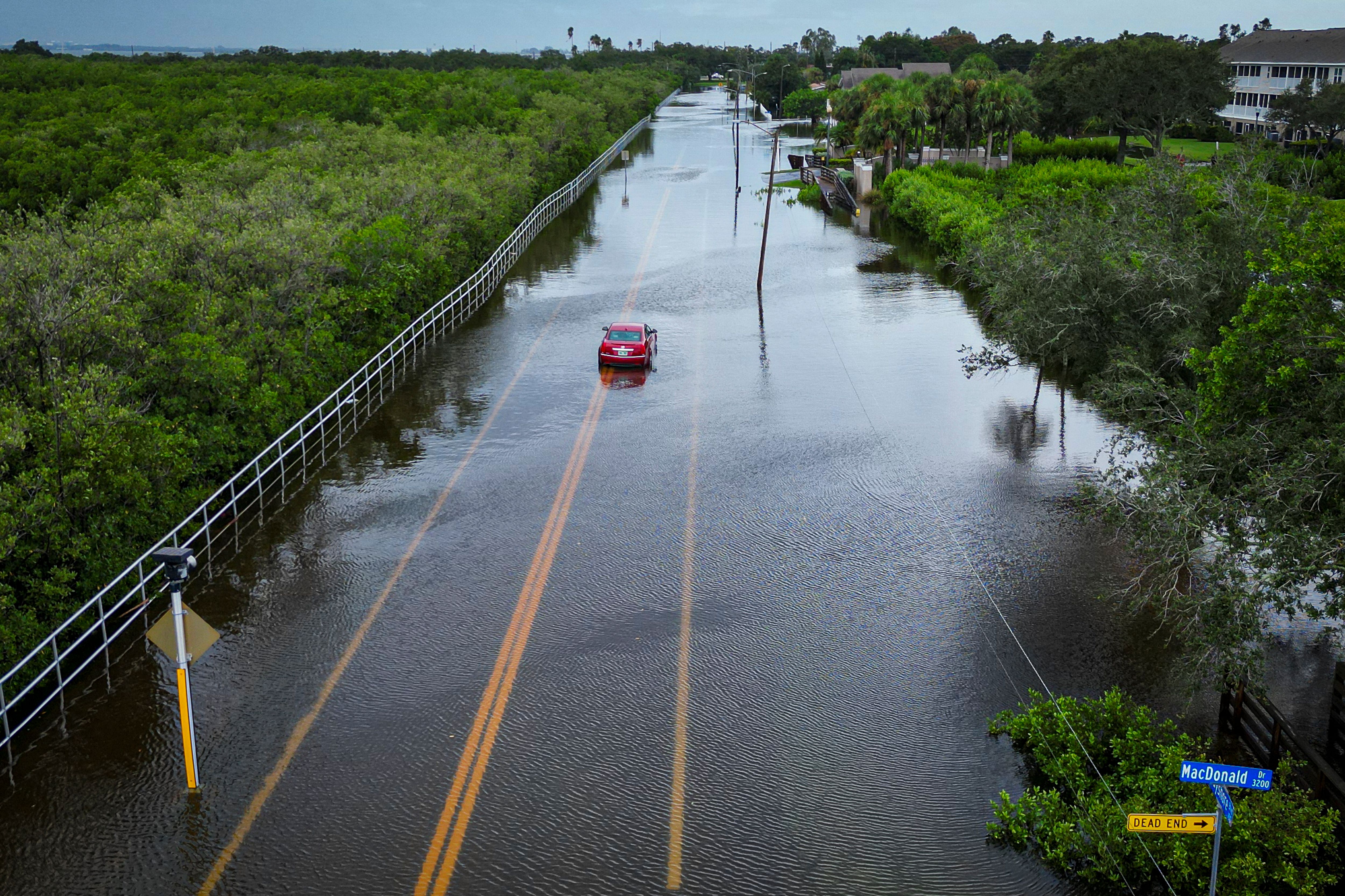 A car drives through a flooded street in Tampa, Florida, Aug. 30, 2023, after Hurricane Idalia made landfall.