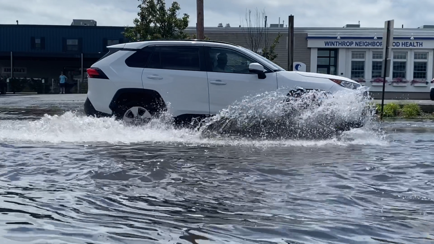 Car drives through flooded street