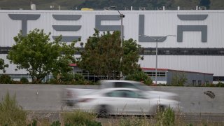 Vehicles pass the Tesla Inc. assembly plant in Fremont, California, on May 11, 2020.