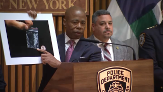 Eric Adams holds image of fentanyl during a police press conference