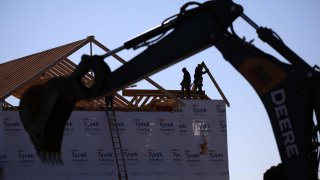 Contractors build the framing of a roof on a house under construction at the Norton Commons subdivision in Louisville, Kentucky, on Tuesday, Feb. 8, 2022.