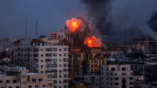 A smoke rises and ball of fire over a buildings in Gaza City on October 9, 2023 during an Israeli air strike.