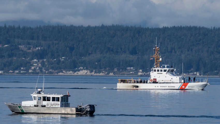 A U.S. Coast Guard boat and Kitsap, Wash., County Sheriff boat search an area, Monday, Sept. 5, 2022, near Freeland, Wash.