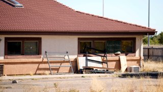 FILE - A sign covers the broken back window of the Return to Nature Funeral Home