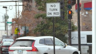 A passenger vehicle makes a right turn on red at an intersection that prohibits the turn Tuesday, Oct. 31, 2023, in Chicago