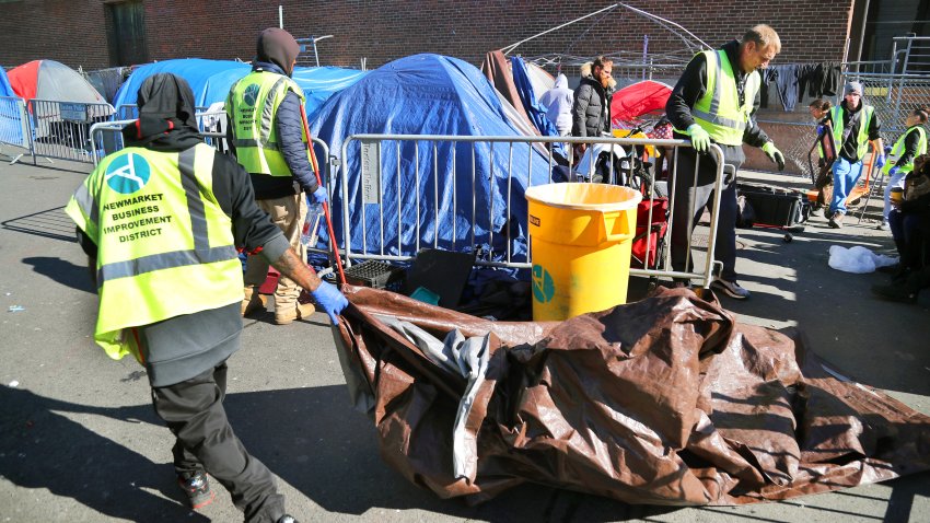 Boston, MA – October 31: A worker with the Newmarket Business pulls a tarp that was the floor of a tent as work is underway to clear the tents on Atkinson Street in an area known as Mass and Cass as Boston approved an ordinance that would allow the removal of the tents by Nov. 1.