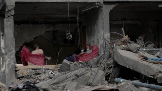 Palestinians sit in their home destroyed in the Israeli bombardment of Al Zawayda, central Gaza Strip,