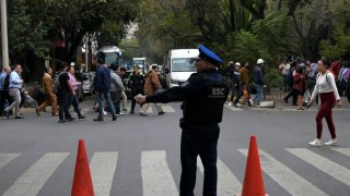 A policeman directs traffic after an earthquake in Mexico City on December 7, 2023.