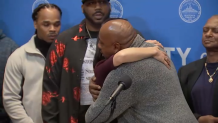 Joey Bennett hugs Boston Mayor Michelle Wu at a news conference Wednesday, Dec. 20, 2023, where the mayor offered an apology on behalf of the city for the unfounded arrests of two men, including a relative of Bennett's, as they investigated the shooting death of Carol Stuart in 1989.