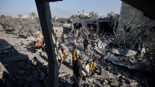 Palestinians inspect the damage of a destroyed house following Israeli airstrikes on Khan Younis, Southern Gaza Strip, Sunday, Dec. 31, 2023.