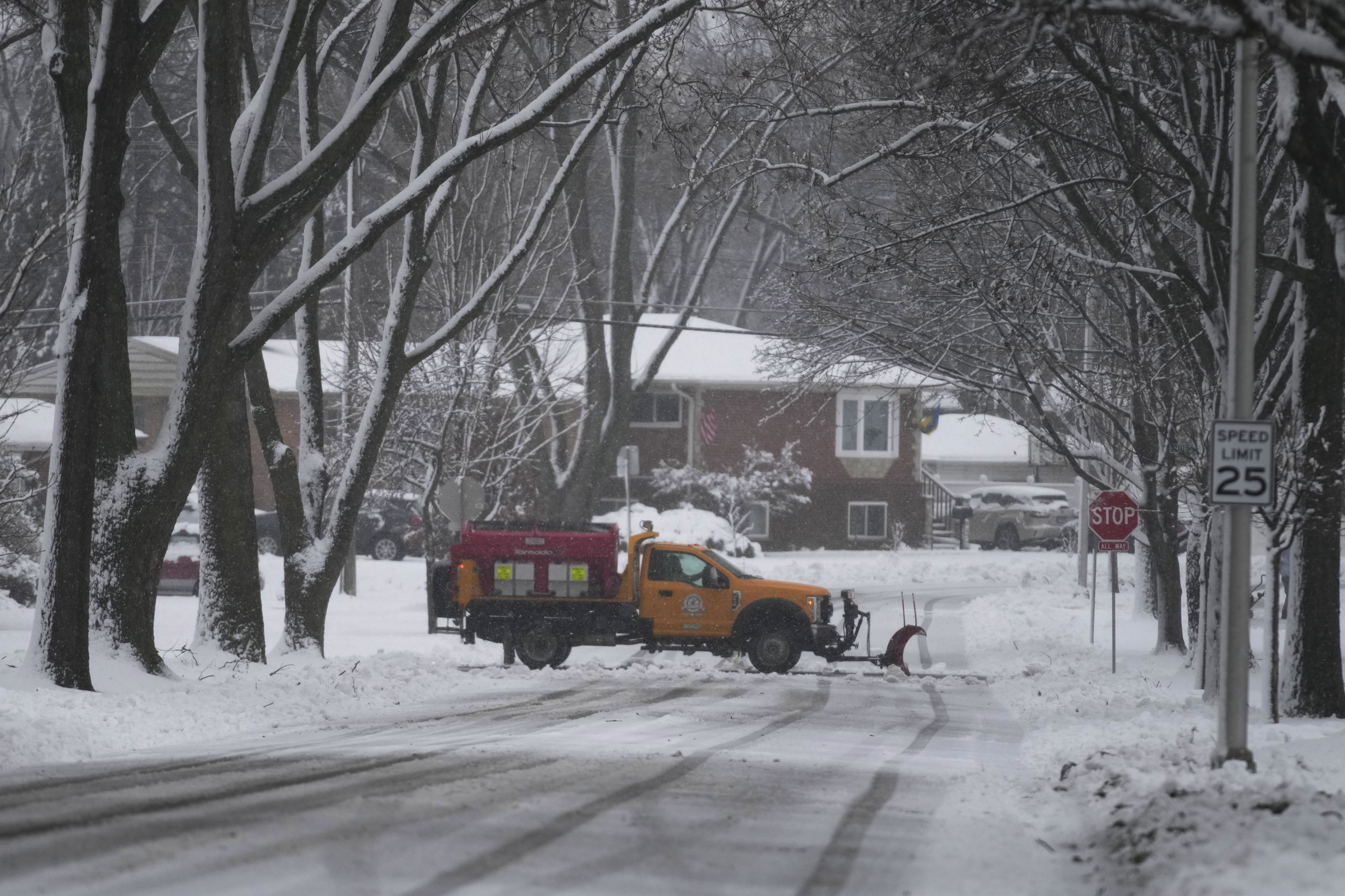 A snow plow cleans the road as a winter storm arrives in Wheeling, Ill., Friday, Jan. 12, 2024.