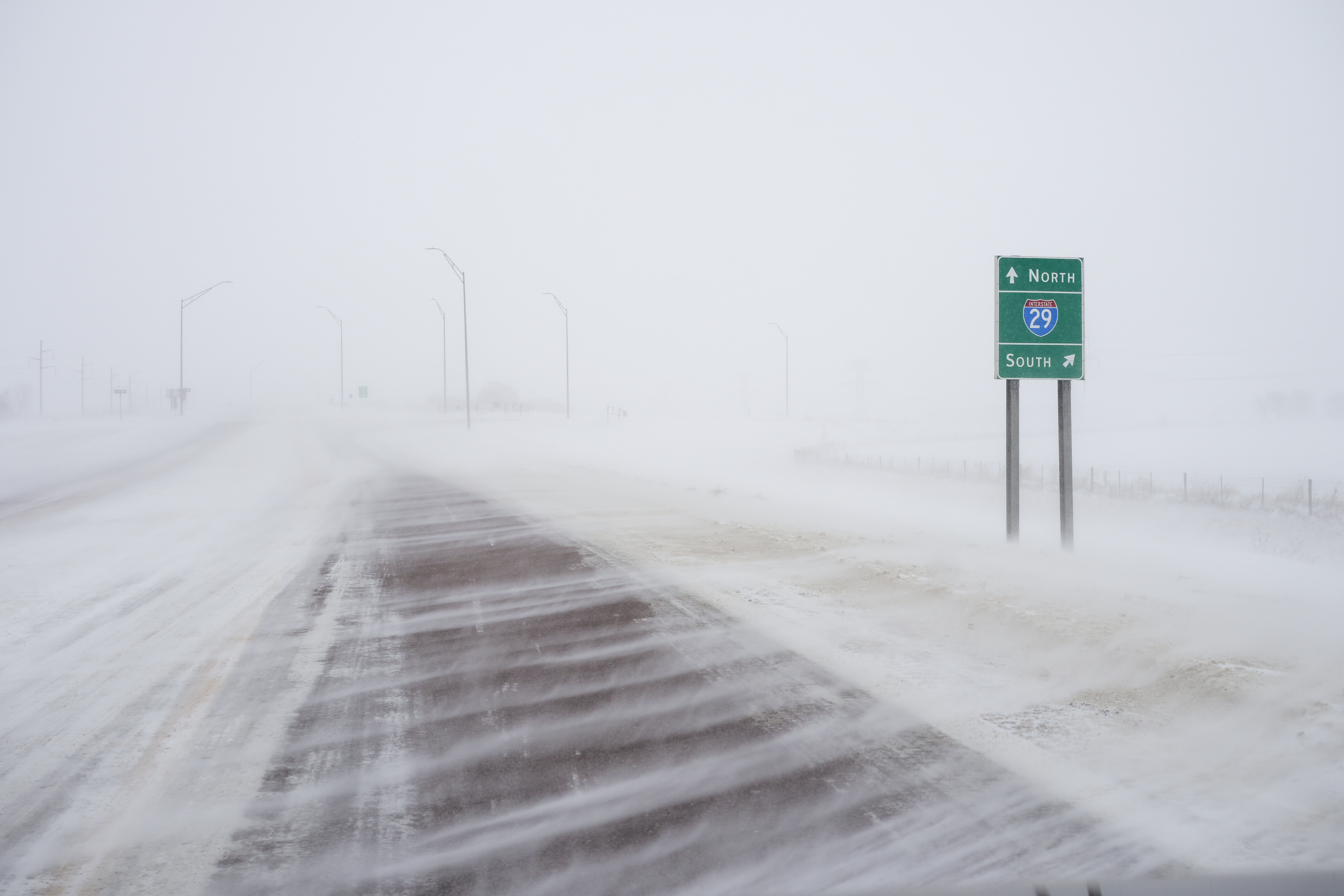 Snow blows across 260th street at the Interstate 29 overpass in Salix, Iowa, during a winter storm, Friday, Jan. 12, 2024.