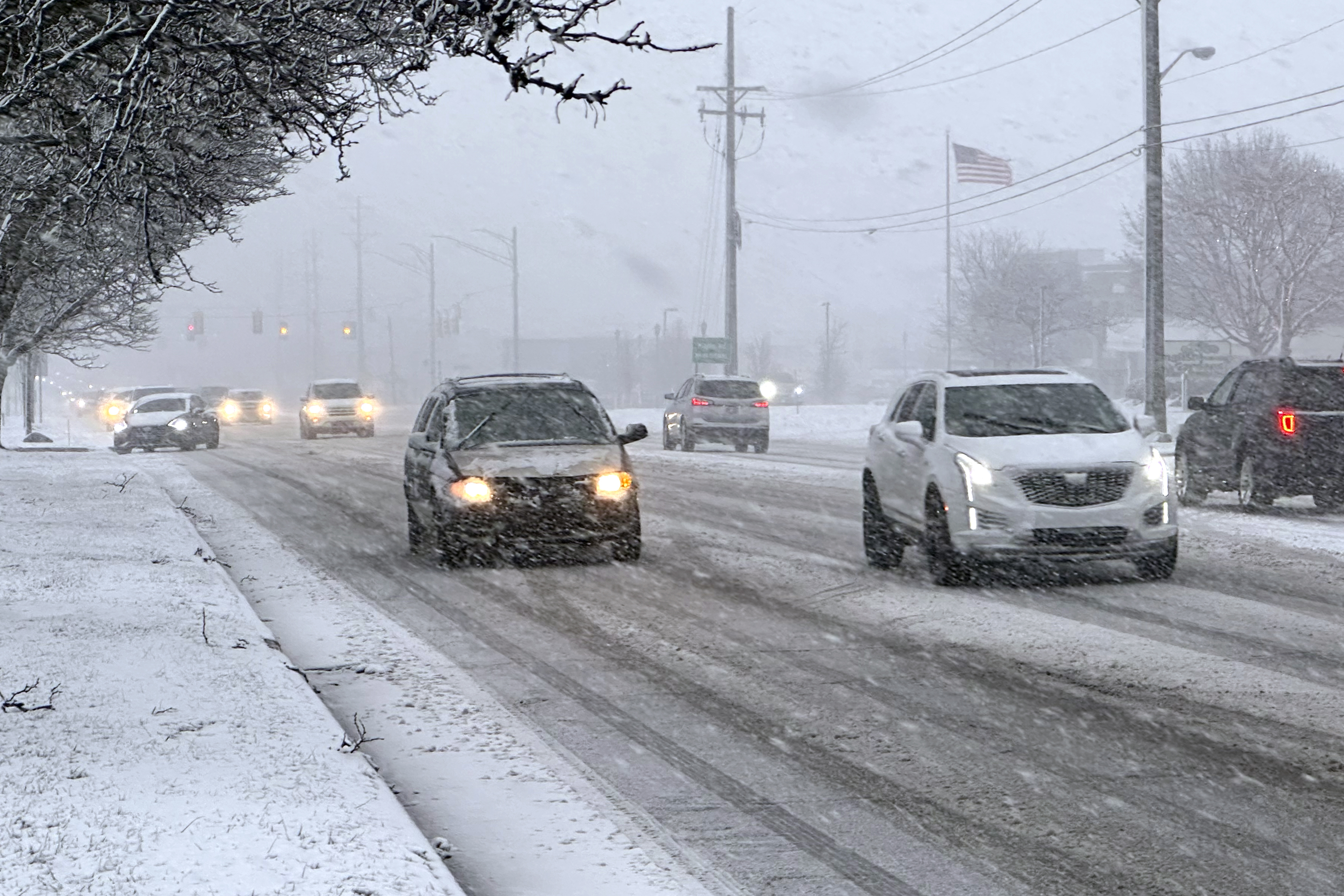 Early rush hour traffic is seen along Orchard Lake Road in West Bloomfield, Mich., shortly after the start of a winter storm Friday, Jan. 12, 2024.