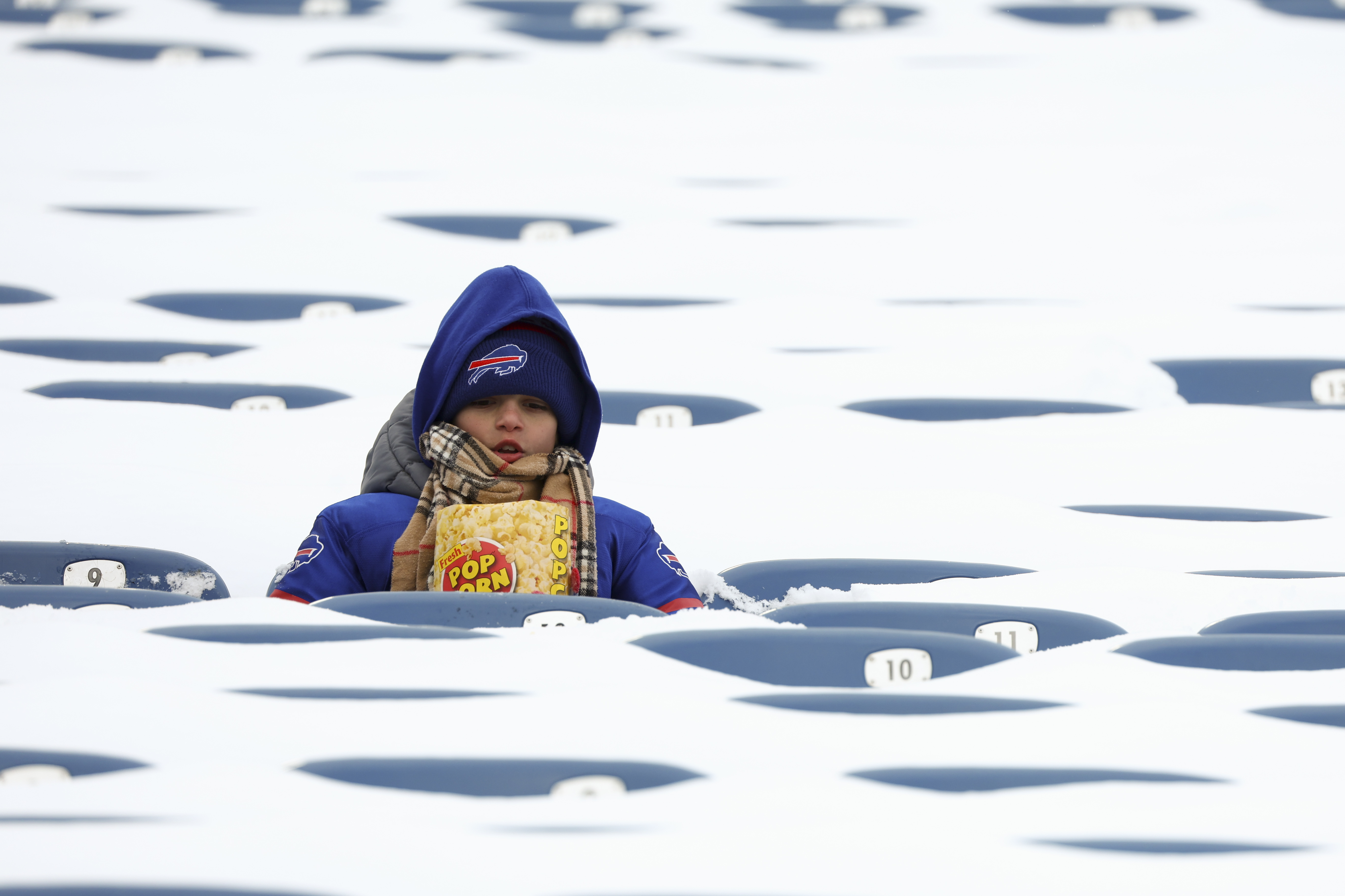 A Buffalo Bills fan sits amongst snow covered seats while waiting for the start an NFL wild-card playoff football game between the Buffalo Bills and the Pittsburgh Steelers, Monday, Jan. 15, 2024, in Buffalo, N.Y.