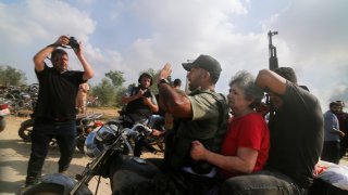 Palestinians transport a captured Israeli civilian.