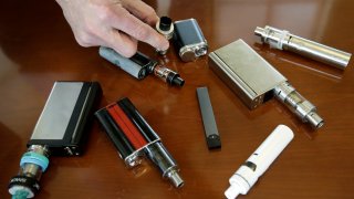 a high school principal displays vaping devices that were confiscated from students.