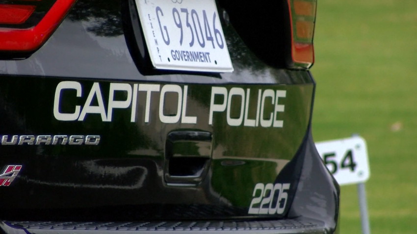 Capitol police vehicle parked outside a green area.