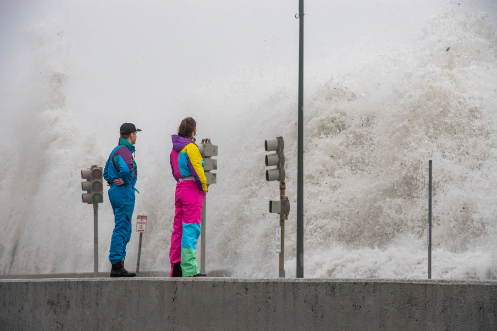 People watch waves crash over the sea wall in Revere, Massachusetts on January 13, 2024. The Massachusetts Emergency Management Agency is reminding residents of the possibility of flooding in low-lying areas and streets as a third storm in a week batters the state. (Photo by JOSEPH PREZIOSO / AFP) (Photo by JOSEPH PREZIOSO/AFP via Getty Images)