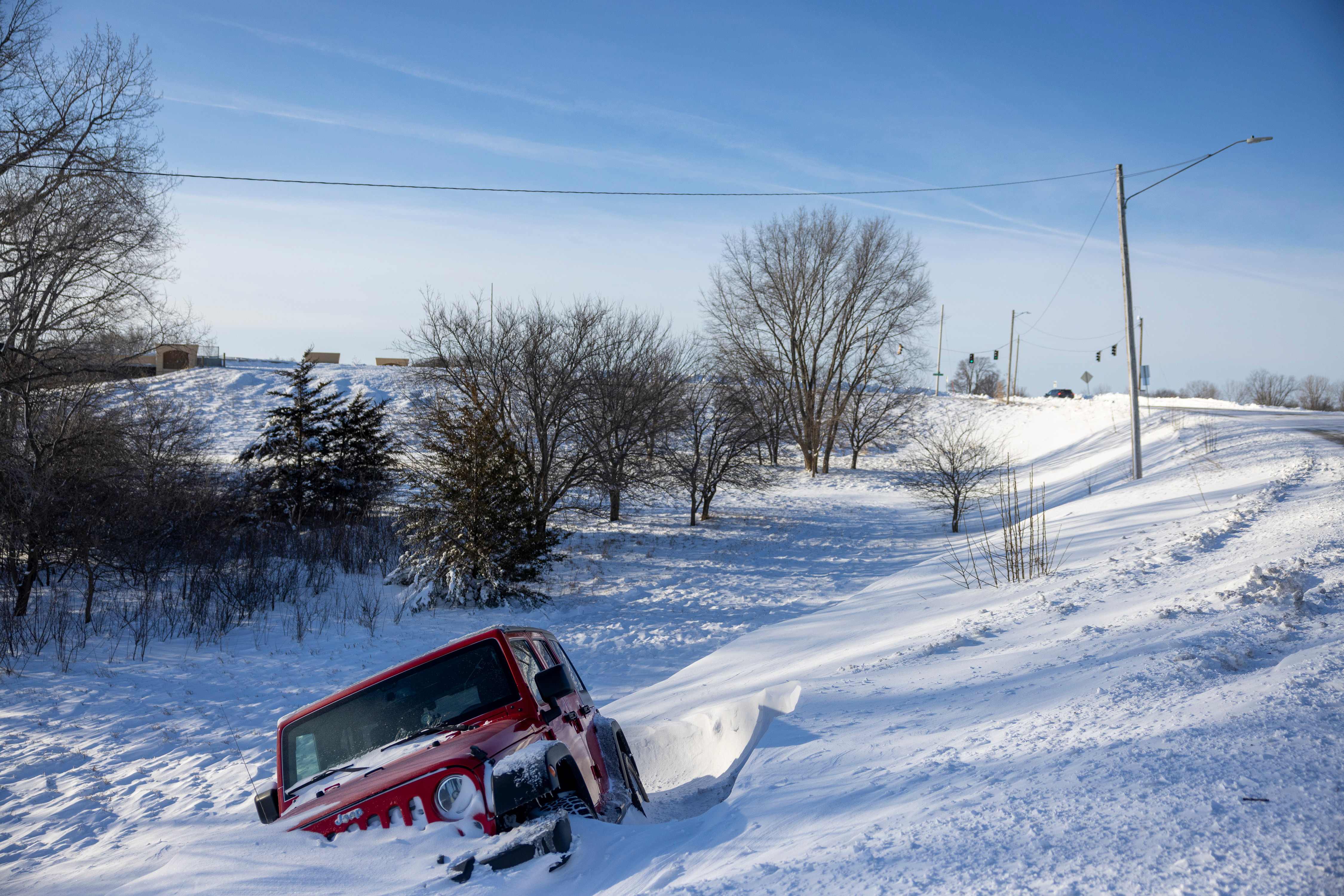 A vehicle off an embankment during a winter storm ahead of the Iowa caucus in West Des Moines, Iowa, on Sunday, Jan. 14, 2024.