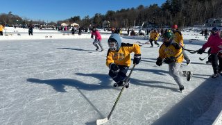 Hockey players go for the puck during the final of the women's open division at the Pond Hockey Classic in Meredith, N.H., on Sunday, Feb. 4, 2024.