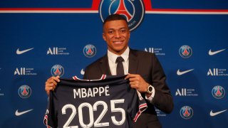 PSG striker Kylian Mbappe shows his jersey during a press conference.