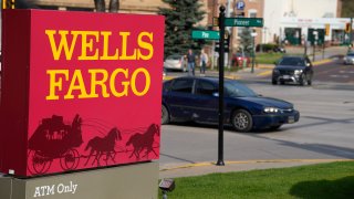 Motorists drive past a sign outside a branch of Wells Fargo bank.