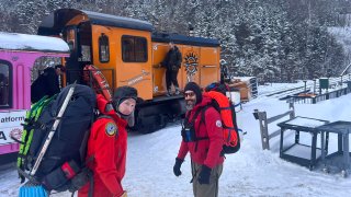 New Hampshire Fish and Game conservation officer Levi Frye, left, and Jeremy Broughton, from Androscoggin Valley Search and Rescue, prepare to head out on a rescue mission at the Cog Railway base station.