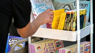 A person picks a banned book from a bookshelf in 2023 in Decatur, Ga. Derek White / Getty Images file