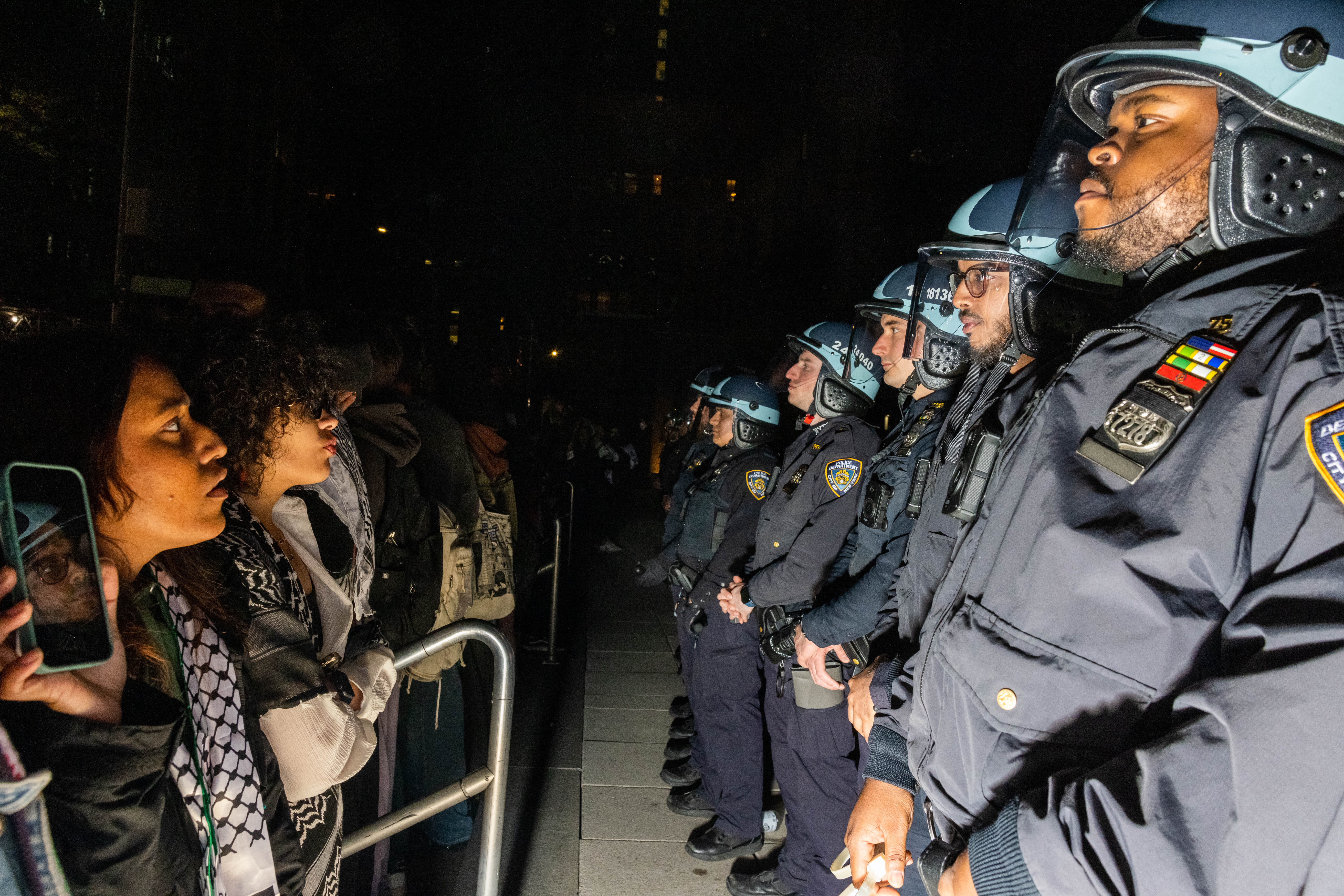 Pro-Palestinian students and activists face police officers as they protest the Israel-Hamas war on the NYU campus on Monday, April 22, 2024.