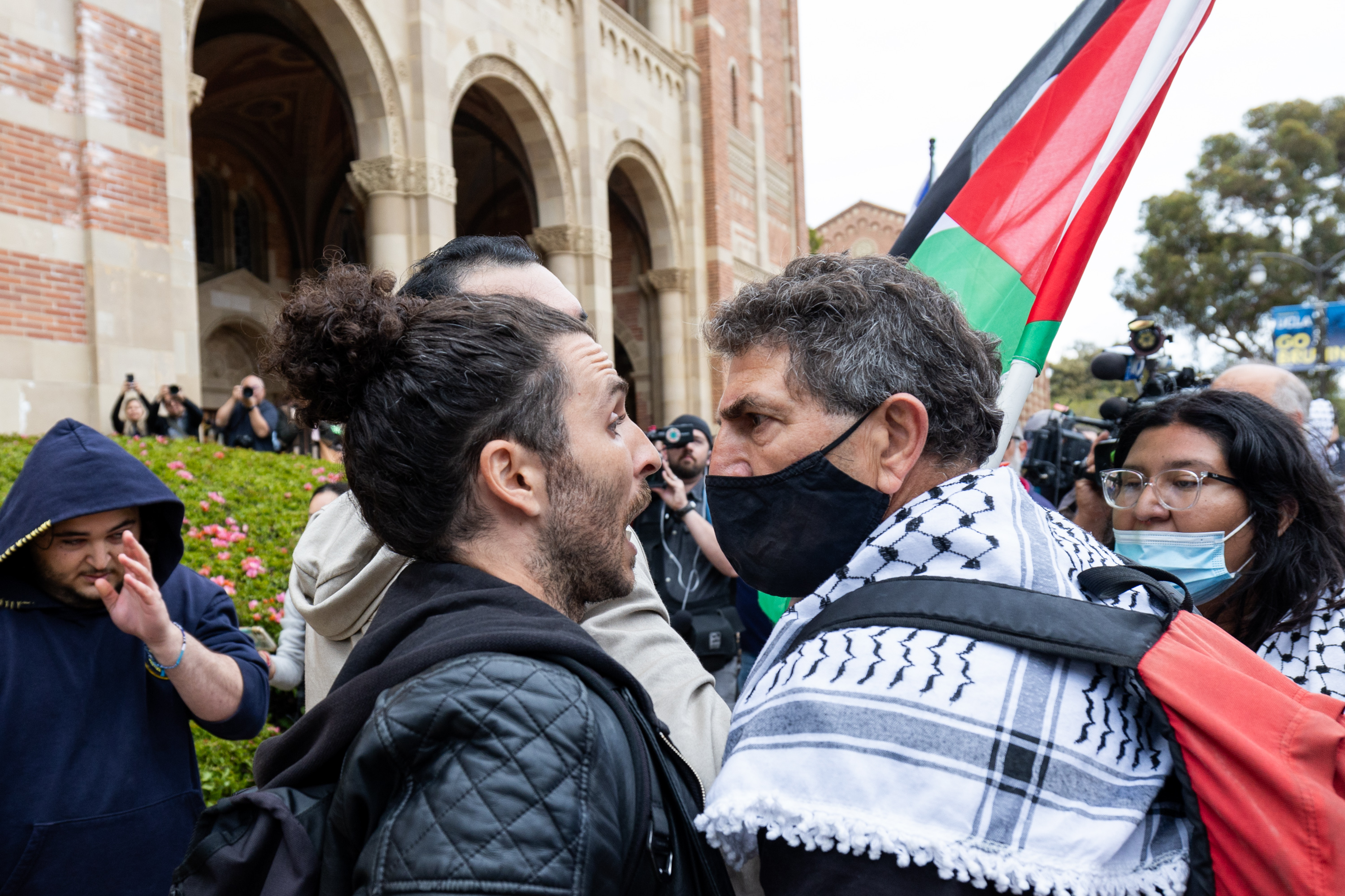 A pro-Palestinian demonstrator and a pro-Israeli demonstrator clash on the UCLA campus on Thursday, April 25, 2024.